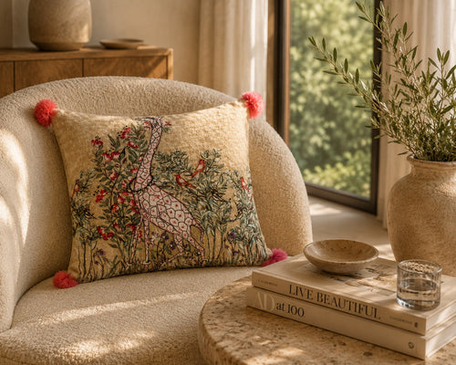 Blossom Giraffe cushion styled on a cream bouclé armchair in morning light
