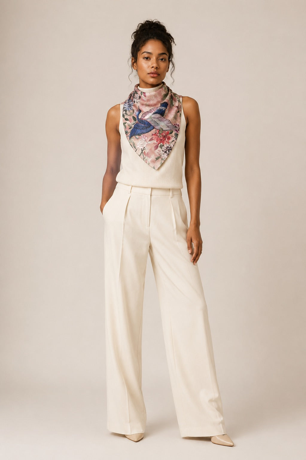 Model wearing the Heron Blossom silk scarf knotted at the neck with cream tailoring