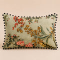 Pheasant Feather cushion — ochre blossom and barred feathers on sage with black pom-pom trim, flat catalogue