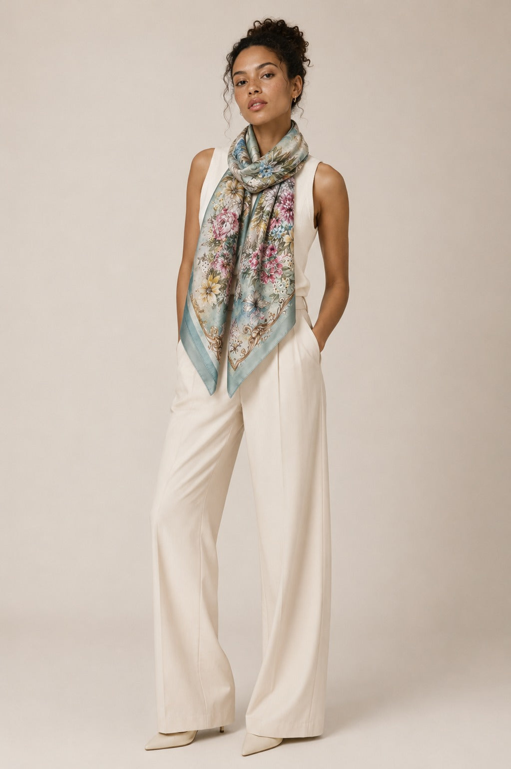 Model wearing the Rose Garland silk scarf draped at the neck with cream tailoring