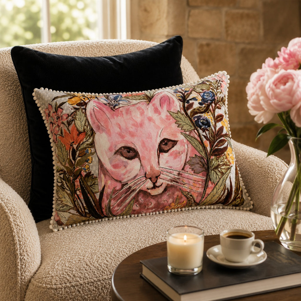 Wildflower Cat Cushion styled on a cream armchair beside pink peonies